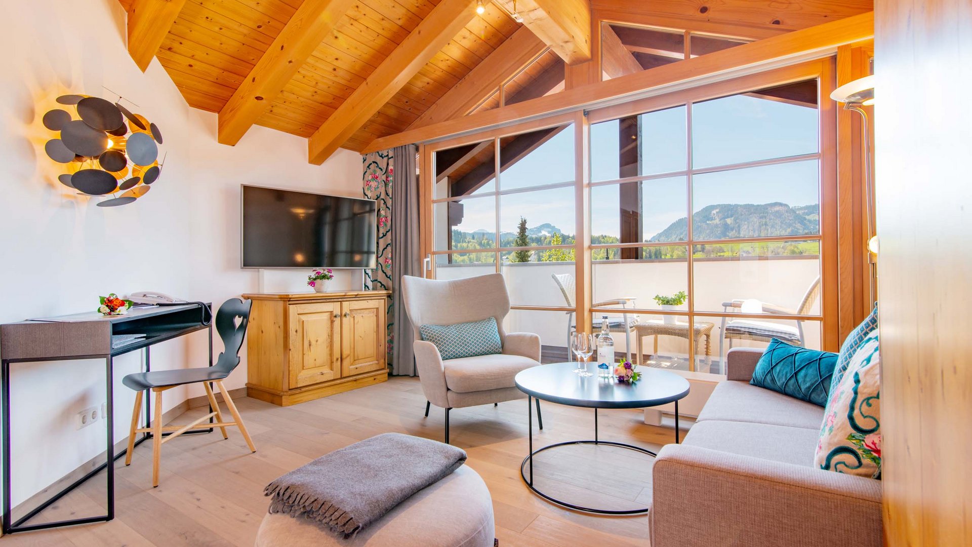 Hahnenköpfle: holiday apartment, lodge & hotel in Oberstdorf Cozy living room with wooden beam ceiling and mountain view through large windows