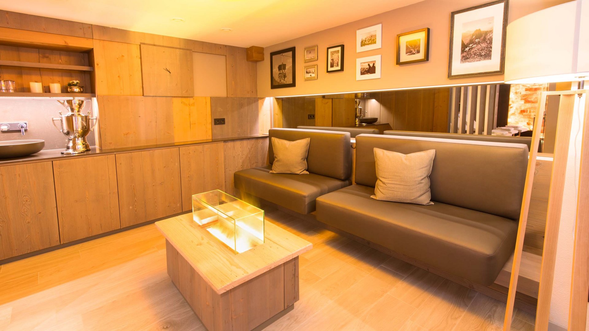 Your wellness hotel in Oberstdorf Modern wooden interior with leather bench and fireplace in bright living room