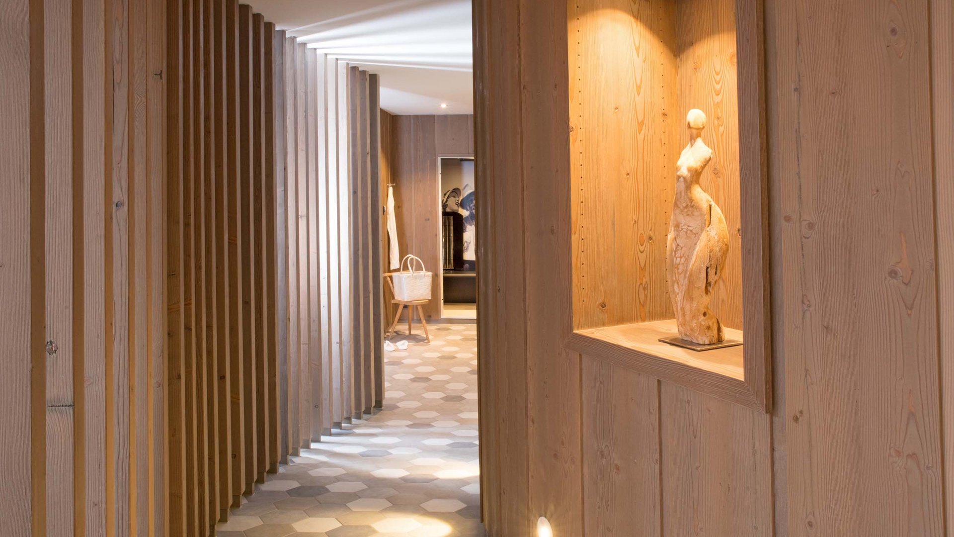 Your wellness hotel in Oberstdorf Hallway with wooden walls and illuminated sculpture in a niche