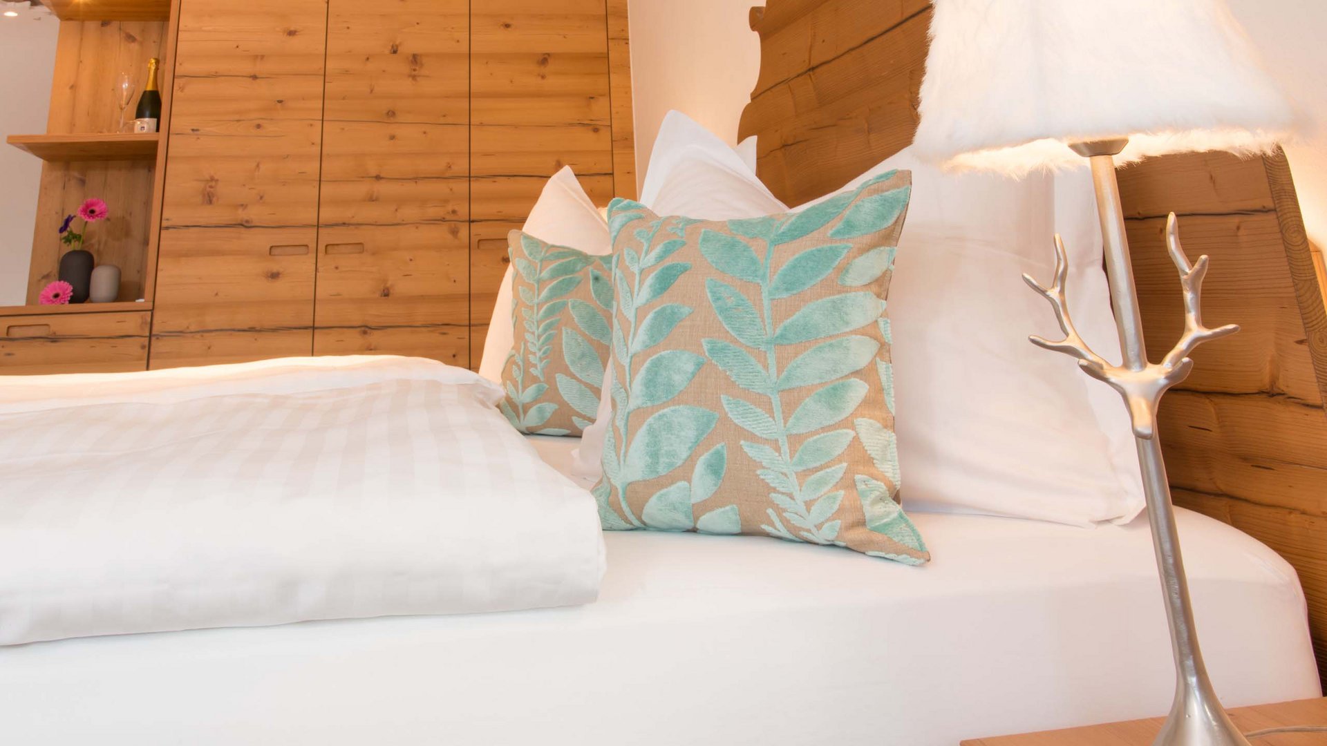 Hotel und Ferienwohnung im Allgäu, Oberstdorf Gemütliches Schlafzimmer mit Holzschrank und dekorativen Kissen