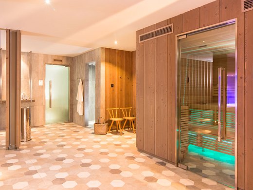 Your wellness hotel in Oberstdorf Bright sauna area with wooden paneling and colored lighting inside