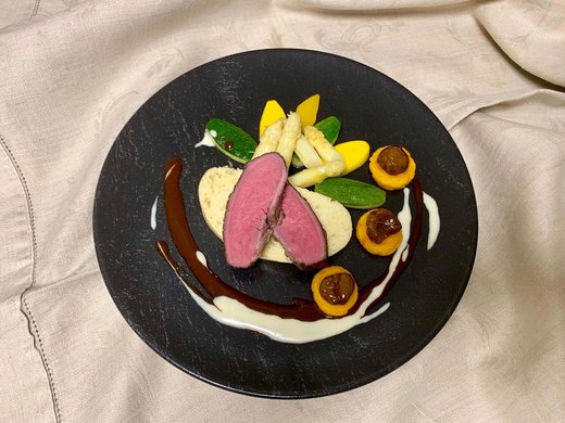 Your hotel in Oberstdorf with half board Gourmet dish with pink cooked meat and vegetables on black plate