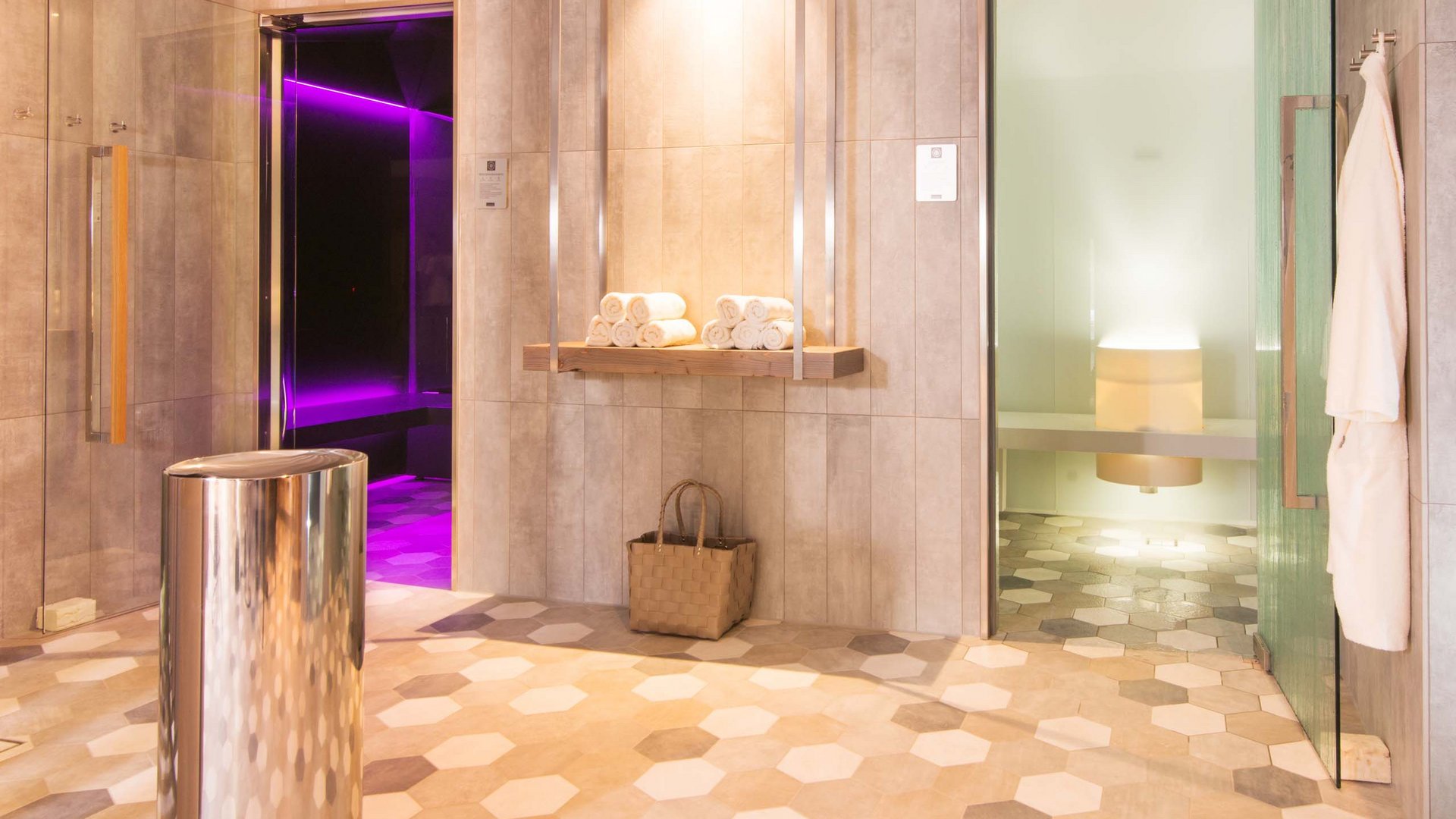 Your wellness hotel in Oberstdorf Modern spa area with sauna and steam room lit with purple and white lights