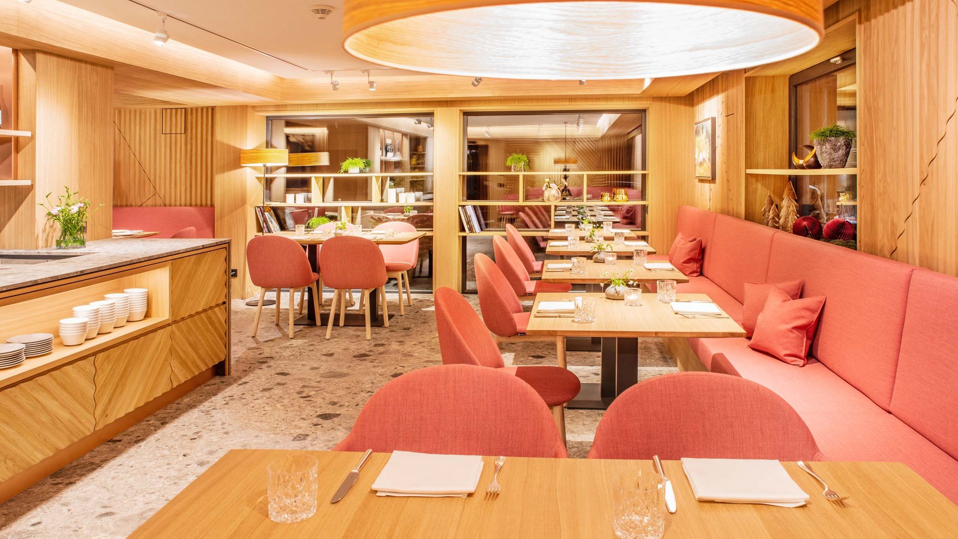 Your hotel in Oberstdorf with half board Modern restaurant interior with pink chairs and wooden tables