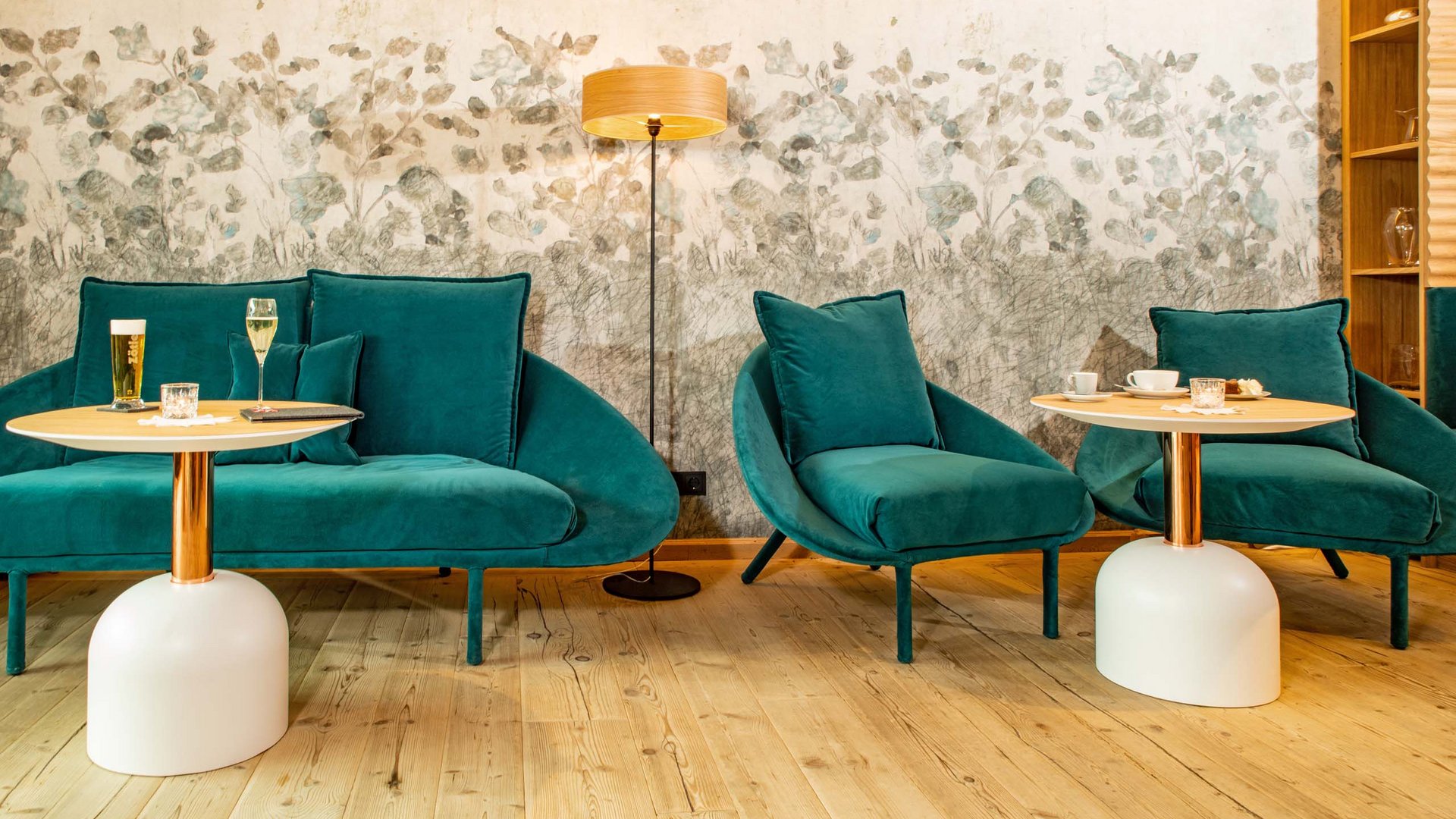 Your hotel in Oberstdorf with half board Cozy seating area with green chairs, tables, and a floor lamp
