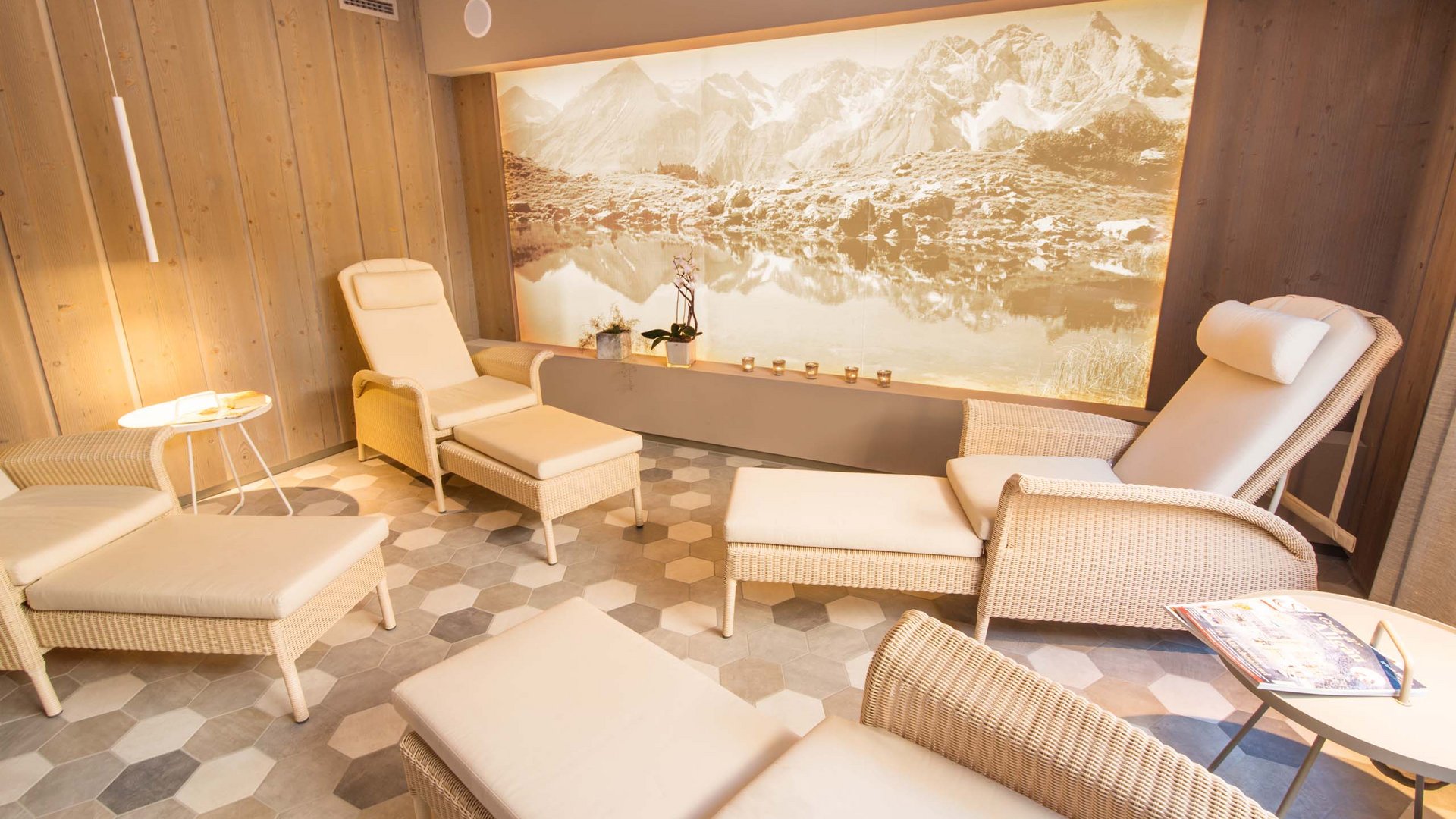 Your wellness hotel in Oberstdorf Cozy relaxation room with loungers and mountain landscape on the wall